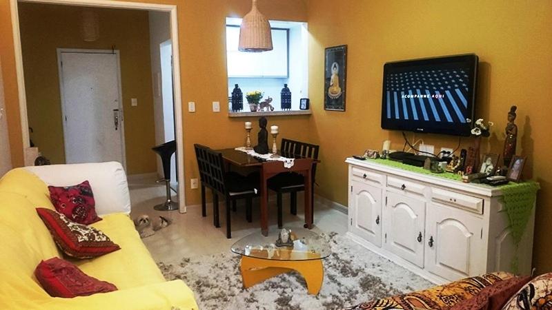 sala de estar con sofá y mesa con TV en Apartamento Aconchegante Copacabana Posto 5, en Río de Janeiro