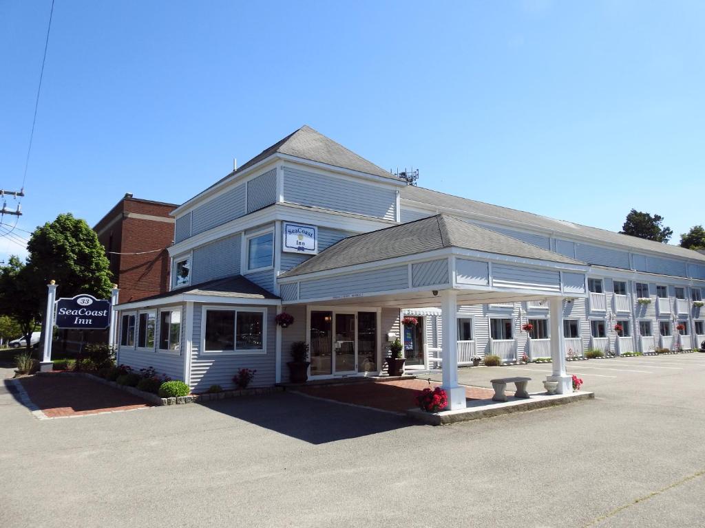 a blue building with a store in a parking lot at SeaCoast Inn in Hyannis