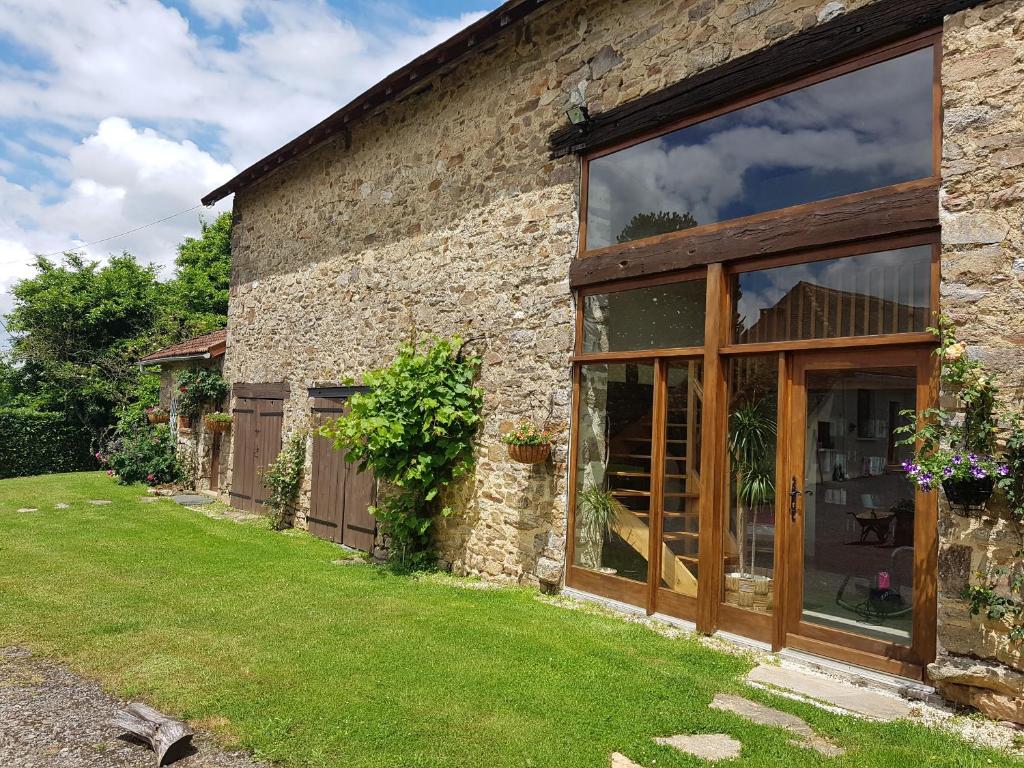 a barn conversion with large glass doors and a yard at L'Horizon - Domaine du Vertendre in Saint-Yrieix-la-Perche