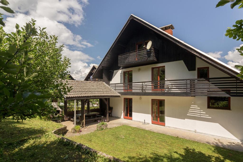 una casa blanca con techo negro y patio en Appleby Apartments Kersnik en Bohinj