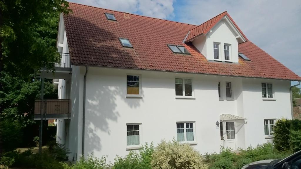 a white house with a red roof at Ostseequartett Whg 5, Zinnowitz in Zinnowitz