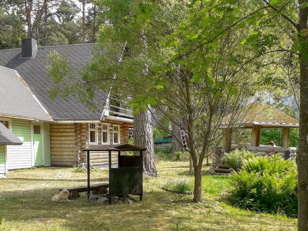 a dog laying on the grass in front of a house at Nature Guest House in Võsu