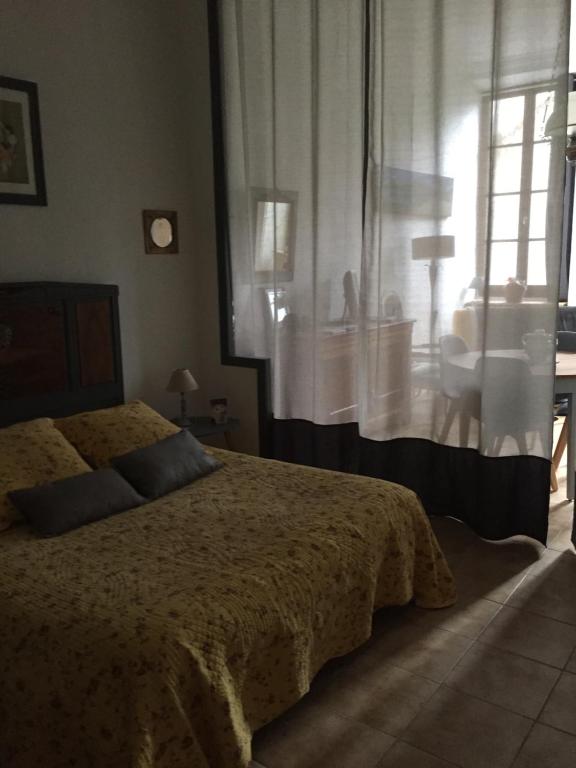 Schlafzimmer mit einem Bett und einem Fenster mit einem Waschbecken in der Unterkunft la chatière in Villefort
