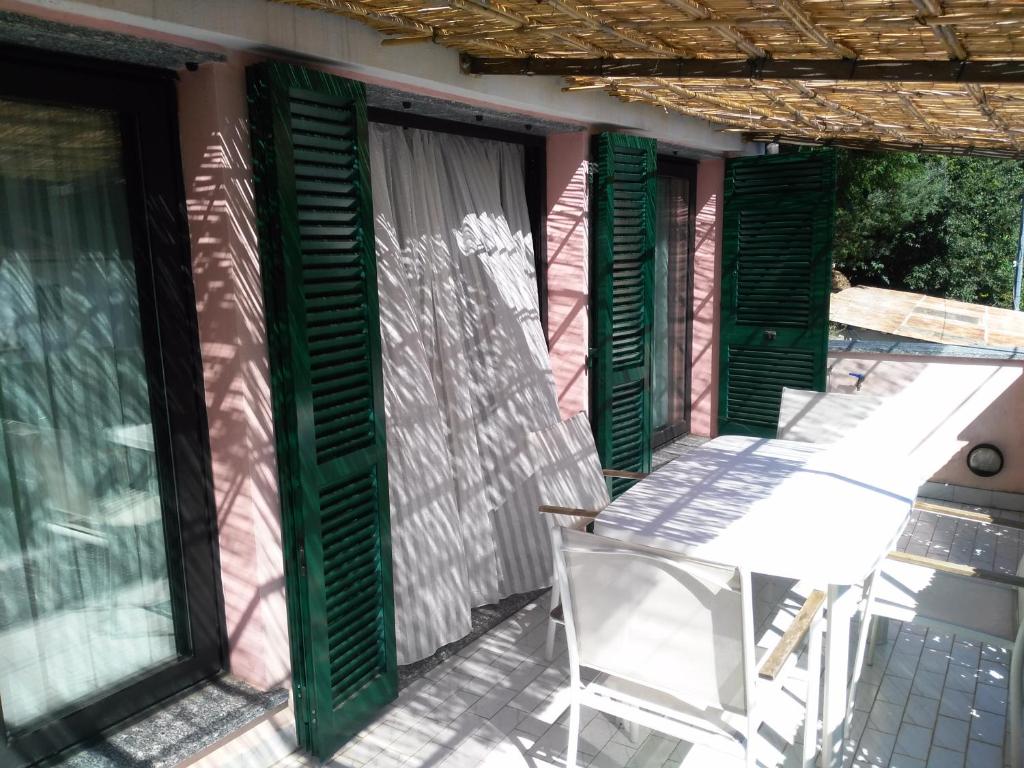 un patio con persiane verdi e una sedia su una casa di La casa di Gio a Varazze