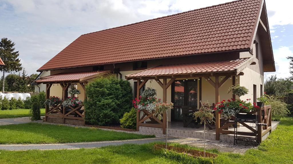 een klein huis met een tuinhuisje en bloemen bij Domek wypoczynkowy Piotr in Stegna