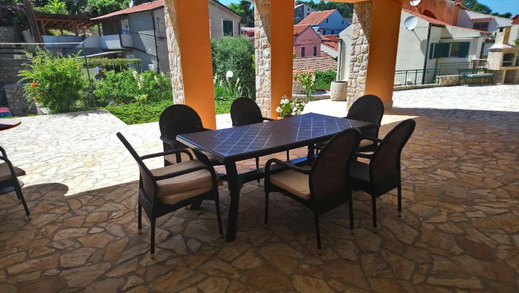 - une table et des chaises noires sur la terrasse dans l'établissement Apartmani Valentina, à Veli Lošinj