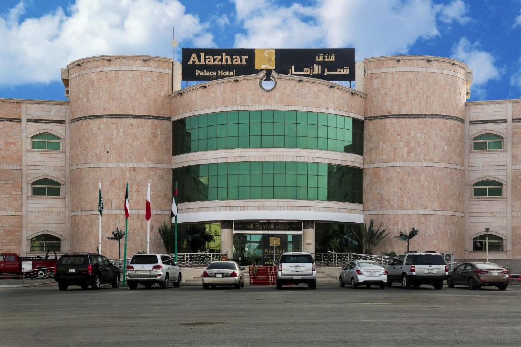 a building with cars parked in front of it at Alazhar Palace Hotel in Al Qunfudhah