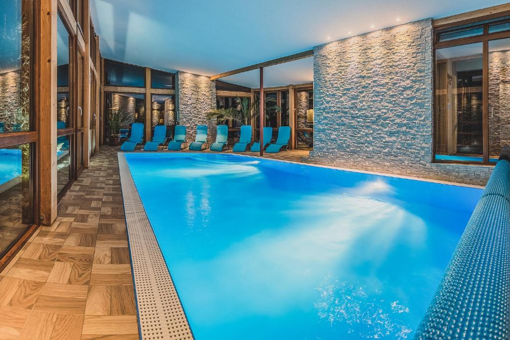 una piscina con sillas azules en un hotel en Apartmány a Štúdia Villa Flora, en Liptovská Sielnica