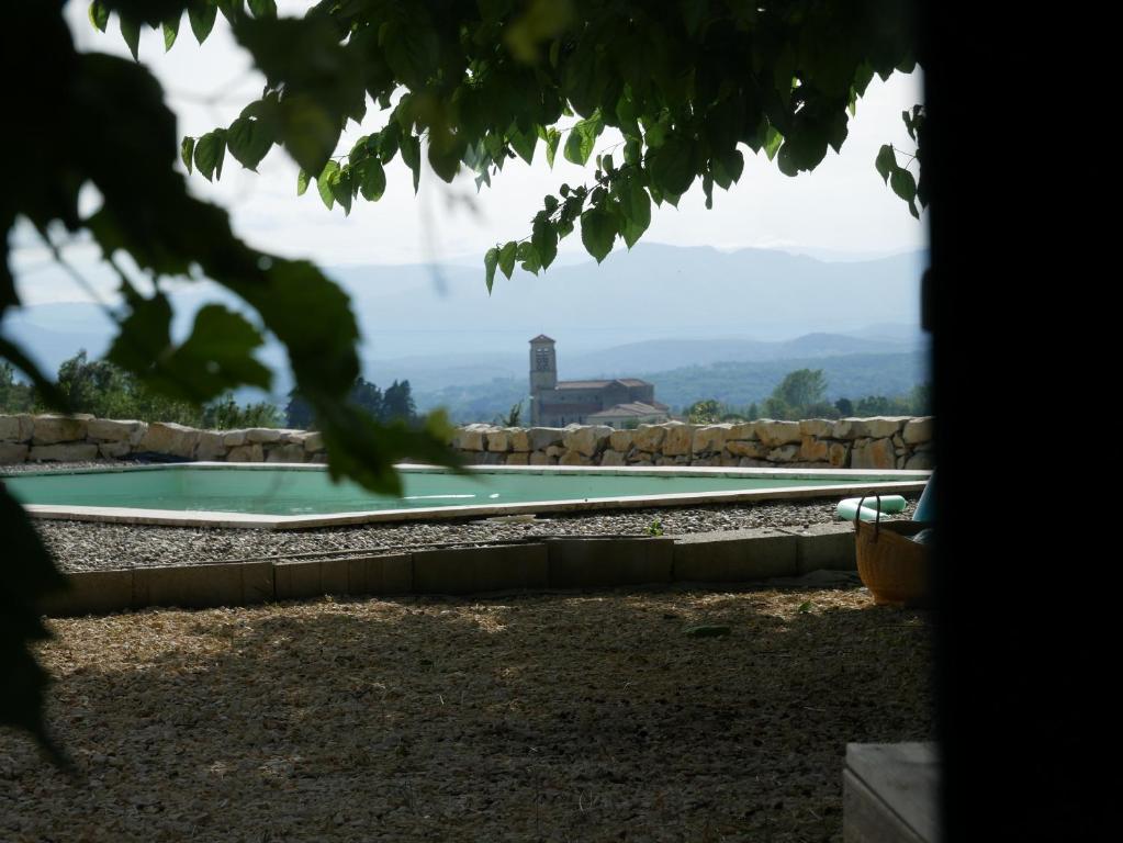 a swimming pool in a yard with a view at Les agaves piscine panoramique vue exceptionnelle in Grospierres