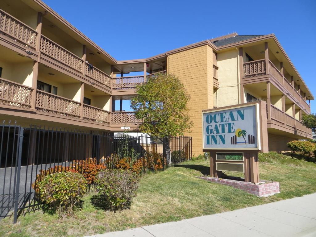 a sign in front of a building with a queen cake inn at Ocean Gate Inn in Santa Cruz