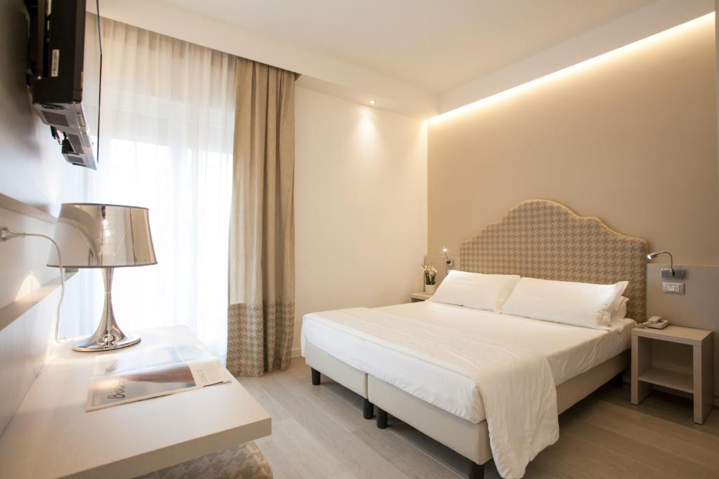 una camera d'albergo con letto e finestra di Hotel Grottamare a Lido di Jesolo