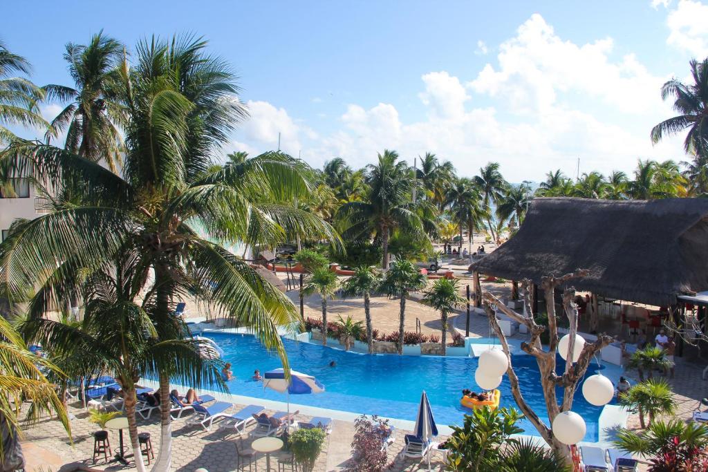 Blick auf einen Pool in einem Resort mit Palmen in der Unterkunft Hotel Posada del Mar in Isla Mujeres