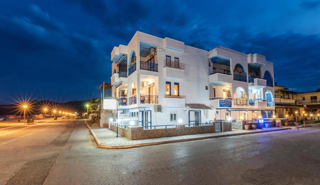 a large white building at night with a street at House Katerina Mediterranean in Sarti