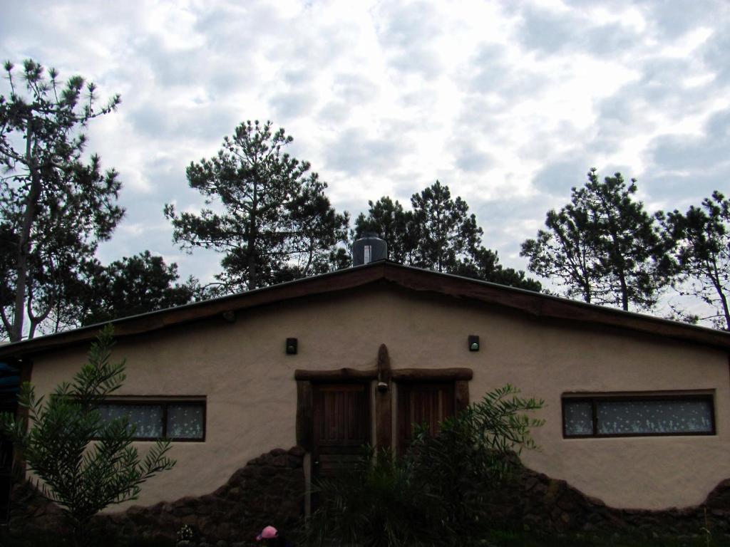 una casa con techo con árboles en el fondo en Punta Avellaneda, en Punta del Diablo