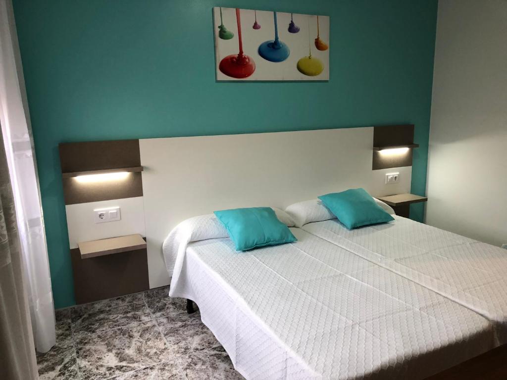 sypialnia z łóżkiem z 2 niebieskimi poduszkami w obiekcie Pension Casa Prieto w mieście Villalonga