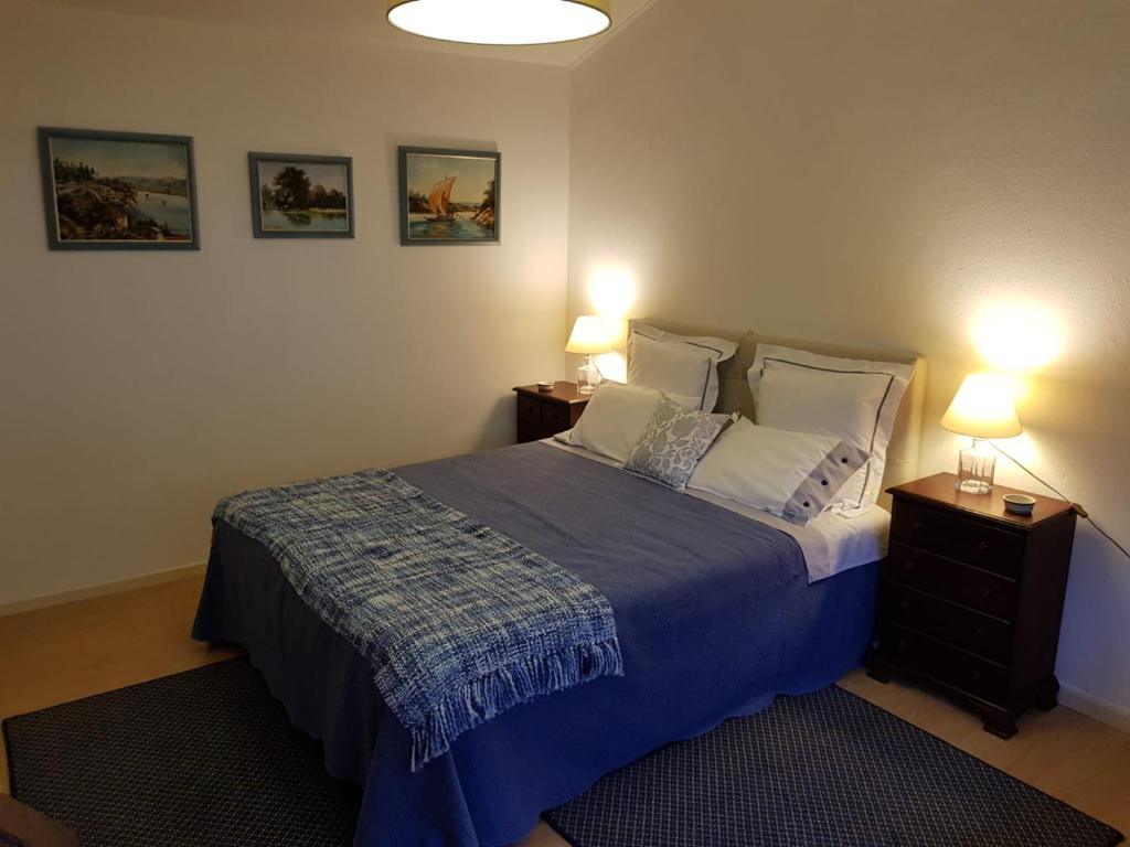 a bedroom with a bed with two night stands and two lamps at Casa do Jardim (Garden House) in Vila do Conde
