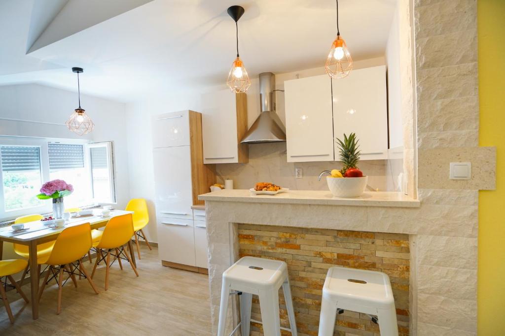 a kitchen with a fireplace and a table and chairs at Apartments Aurora in Zadar