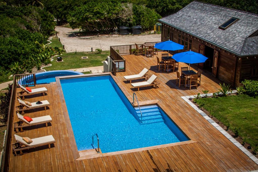 an overhead view of a swimming pool with chairs and umbrellas at Santosha Barbados in Saint Andrew