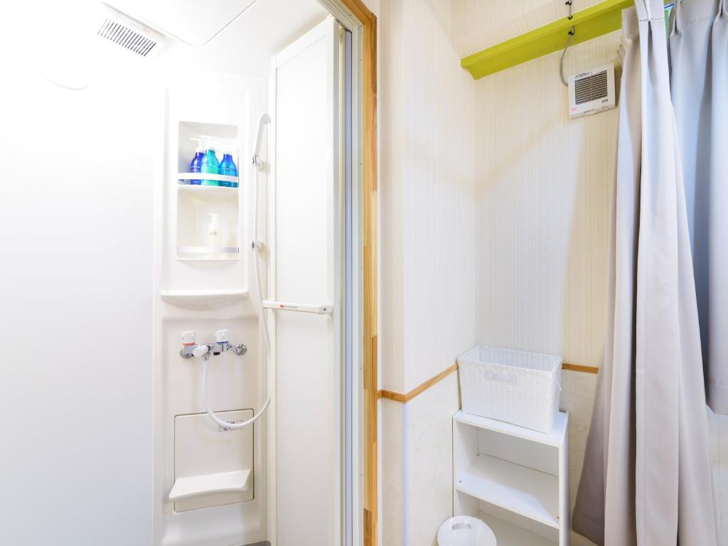 a bathroom with a shower and a toilet at Hotel Abest Naha Kokusaidori in Naha