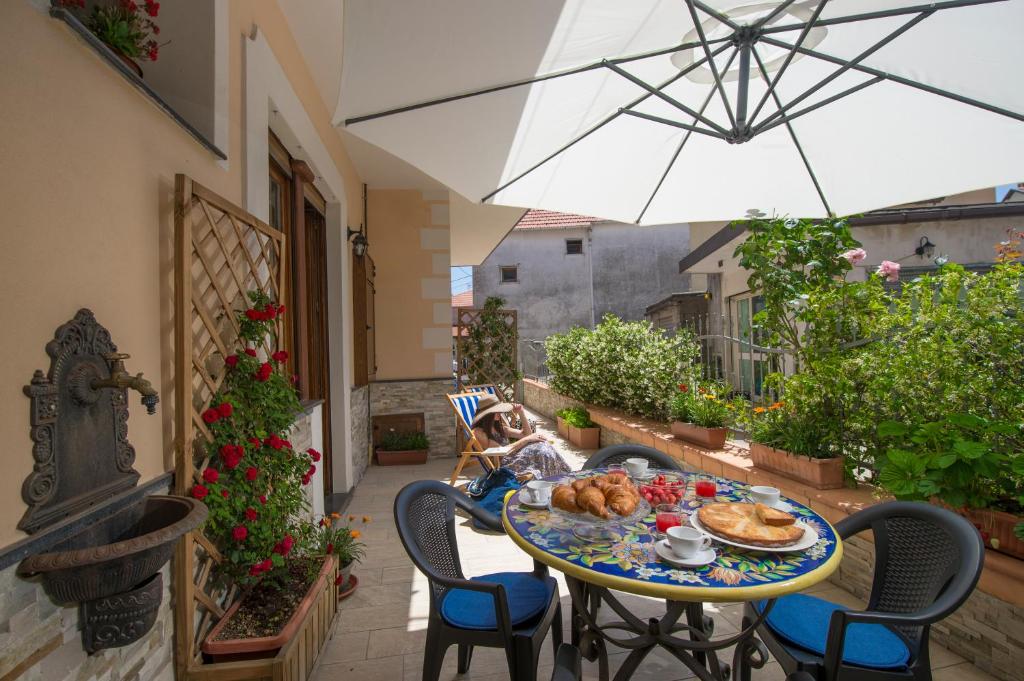 a table with food on it on a patio with an umbrella at Sweet House in Agerola