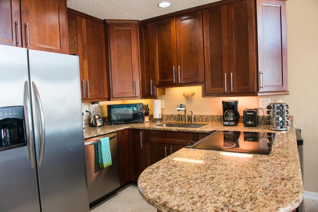 eine Küche mit Holzschränken und einem Edelstahlkühlschrank in der Unterkunft Grand Beach Resort Penthouse 1 in Gulf Shores