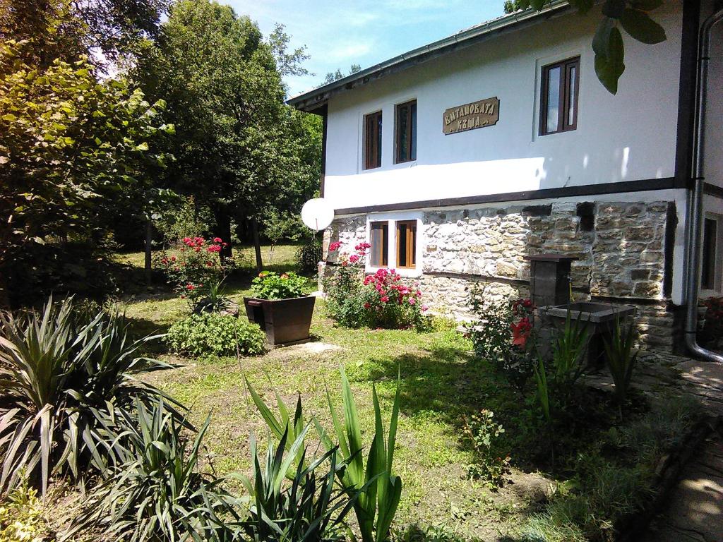 un edificio con un patio con plantas y flores en Vitanova Guest House, en Genchovtsi