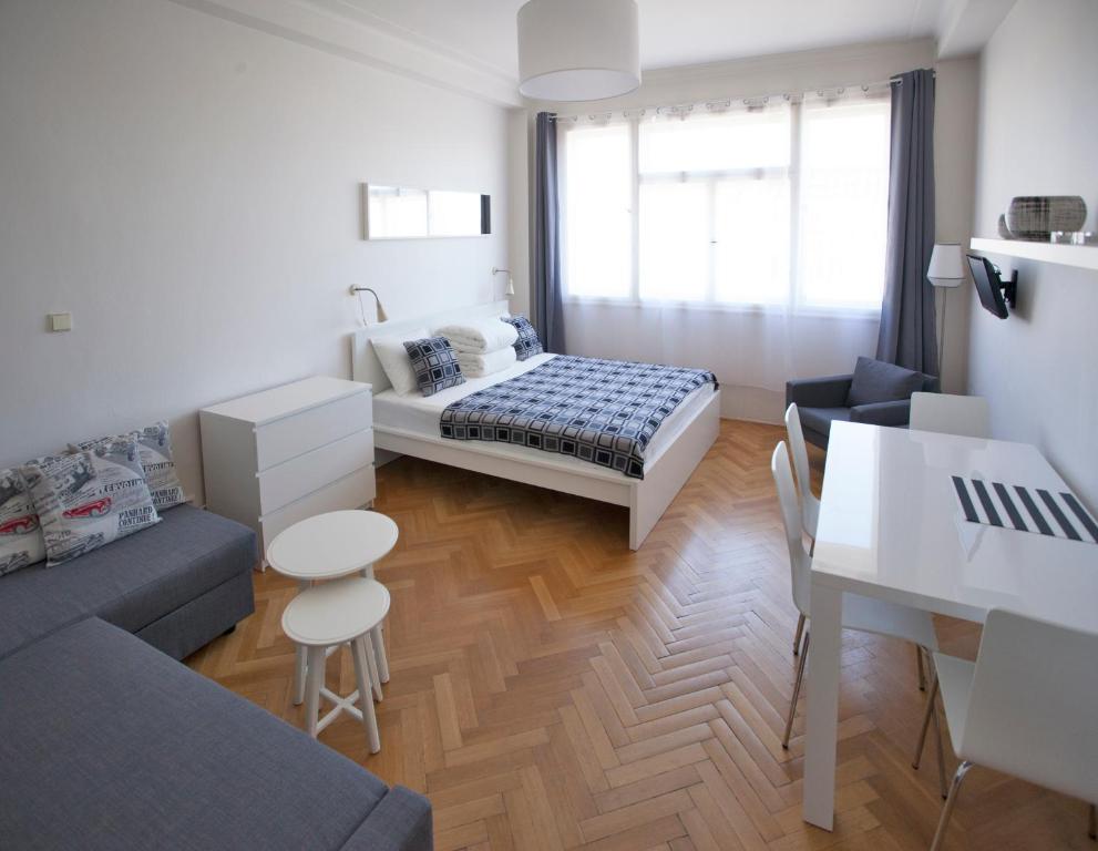 プラハにあるCasa Anna Apartment Opletalovaのベッド1台とソファが備わる小さな客室です。