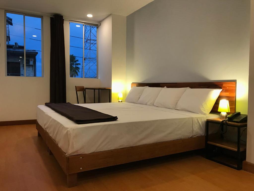 1 dormitorio con 1 cama grande y ventana en Central Bed & Breakfast en Iquitos
