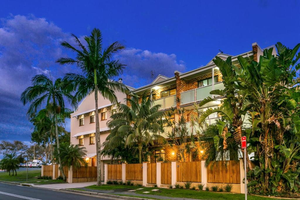 a building with palm trees in front of a street at The Terraces Main Beach in Byron Bay