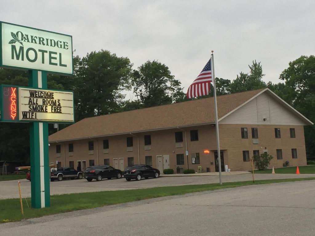 ein Motel mit amerikanischer Flagge vor einem Gebäude in der Unterkunft Oakridge Motel in Newaygo