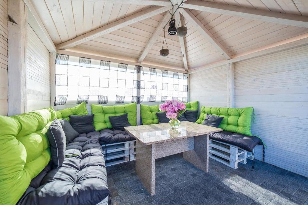 ein Wohnzimmer mit einem grünen Sofa und einem Tisch in der Unterkunft Pensjonat Basia in Dziwnówek