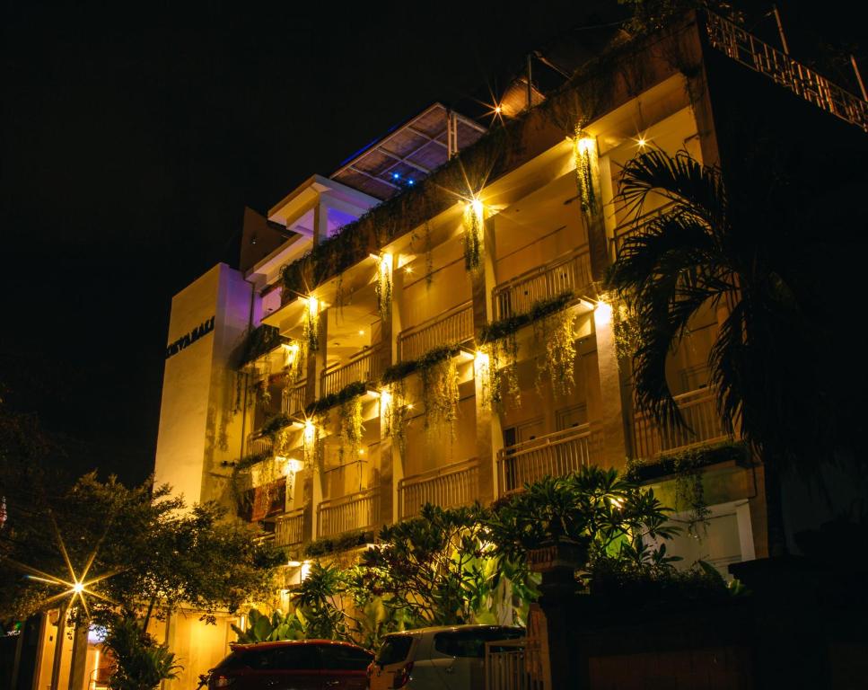 a building with lights on the side of it at night at Deva Bali Apartement in Kerobokan