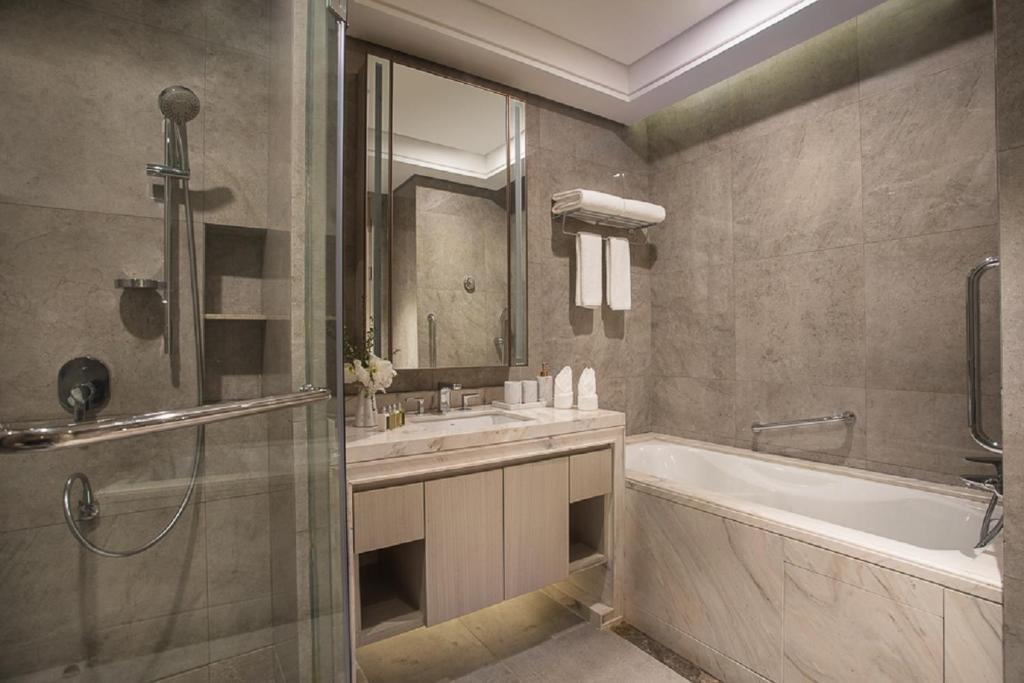 un bagno con vasca, lavandino e doccia di Ascott Harmony City Nantong a Nantong