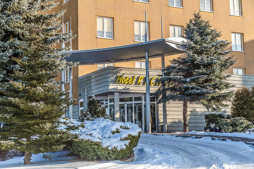 a hotel building with trees and snow in front of it at Hotel Rychło in Bogatynia