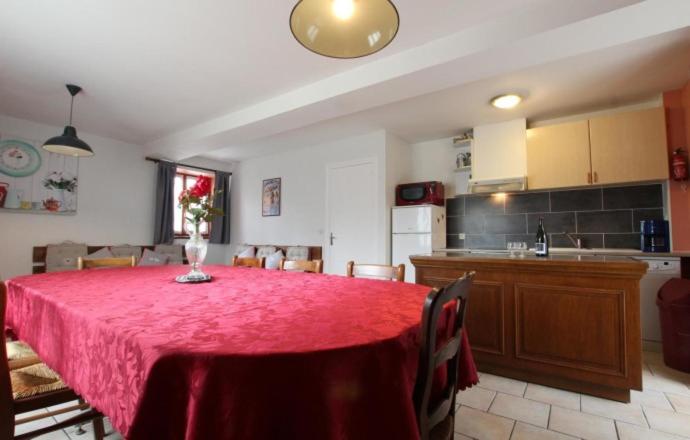 a kitchen with a table with a red table cloth at Gite Jouvin in Cerences