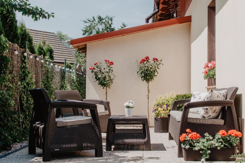a patio with chairs and a table and flowers at Domek Piotr 2 in Stegna