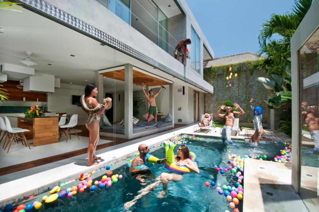 a group of people playing in a swimming pool at 4BR Villa Minggu - Minggu Villas Seminyak in Seminyak