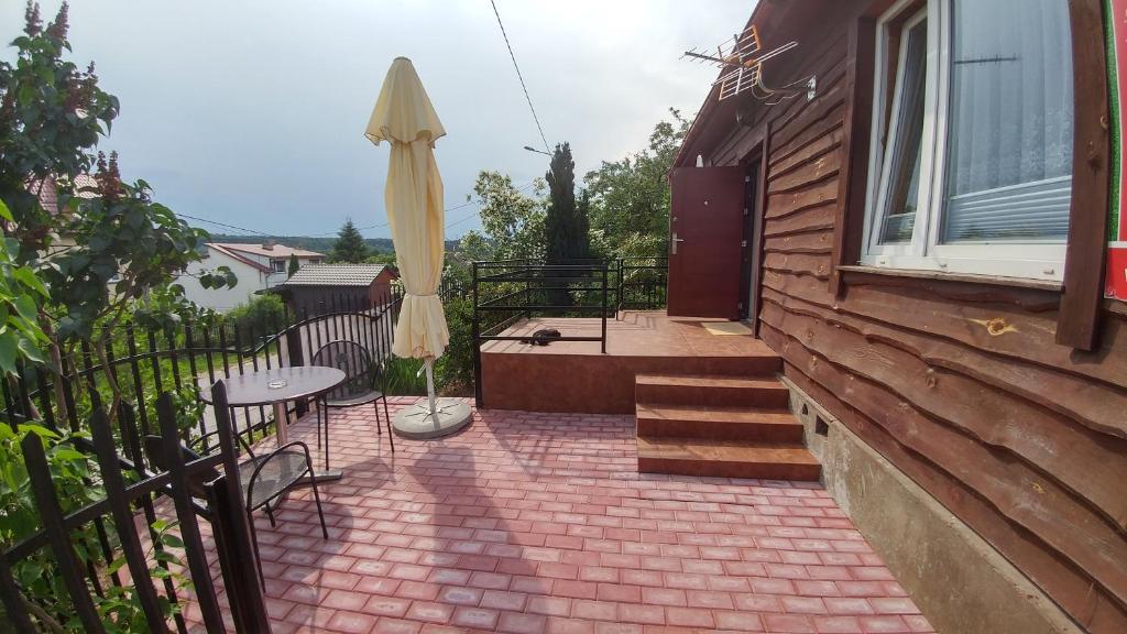 Zagnańsk的住宿－綠色隱居民宿，房屋内带桌子和遮阳伞的天井