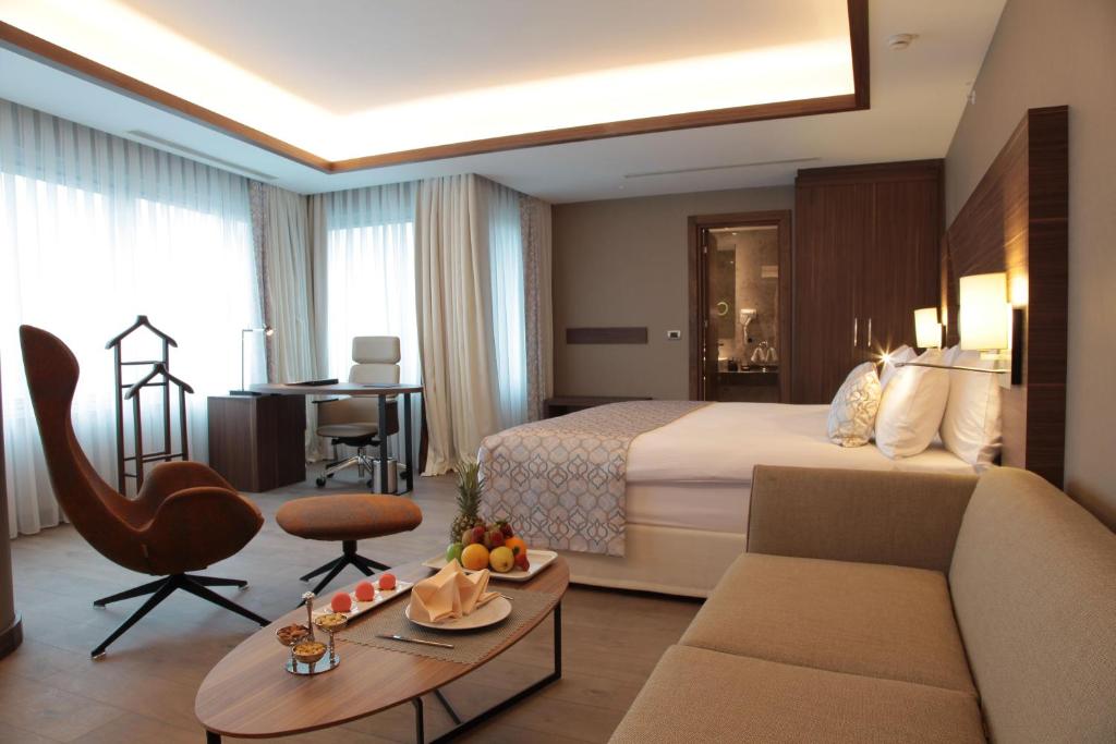 イスタンブールにあるBricks Hotel İstanbulのベッド、ソファ、テーブルが備わるホテルルームです。