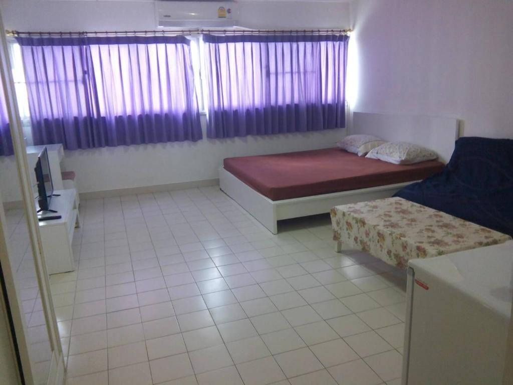 a small room with two beds and a couch at IMPACT Challenger Apartment Hostel Bangkok Thailand in Pak Kret