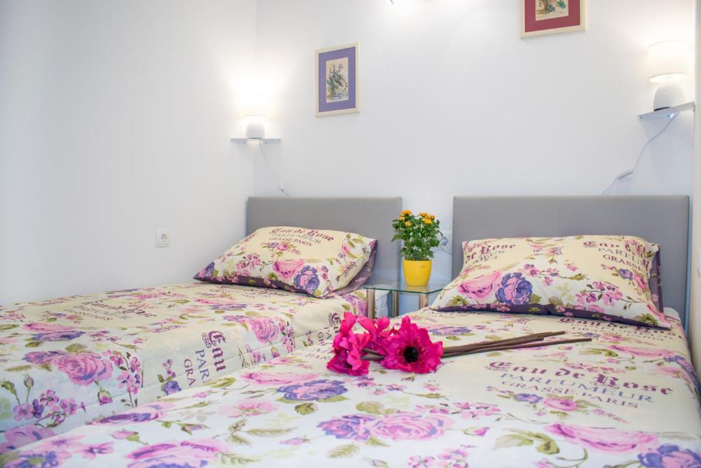 een slaapkamer met twee bedden met roze bloemen erop bij Apartment D&T in Split