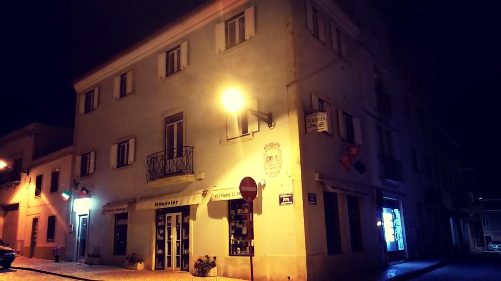 a building with a light on the side of it at night at Rimavier Residence in Peniche