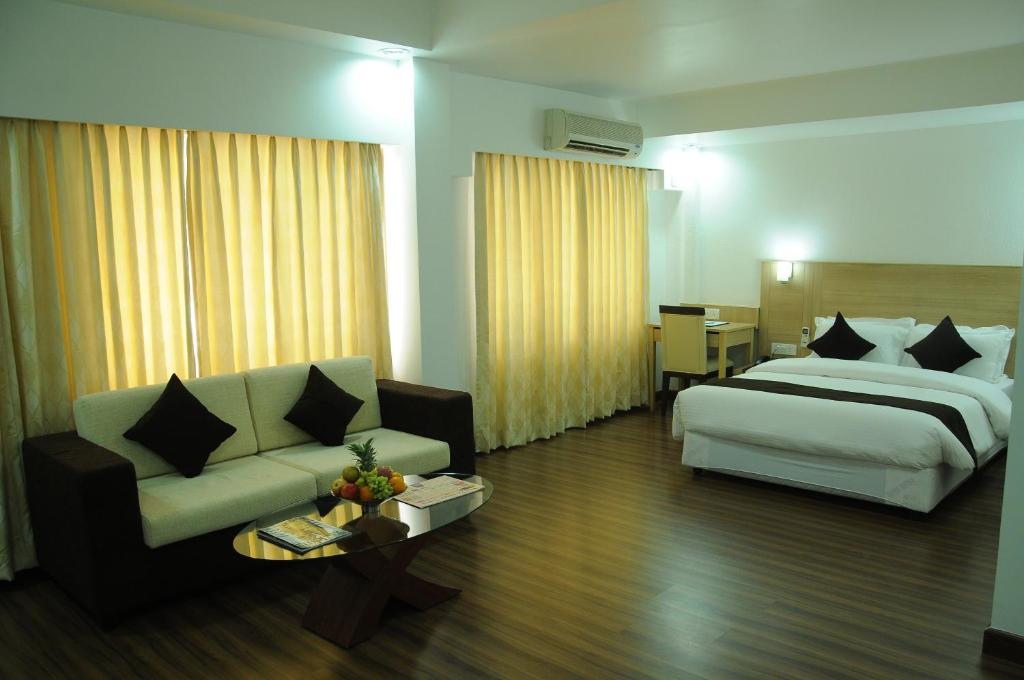 Habitación de hotel con cama y sofá en Hotel Ambient Turret, en Bangalore