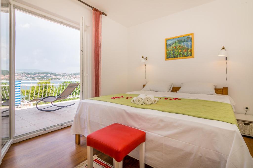 een slaapkamer met een groot bed met een rode kruk bij Apartment "On the beach" in Trogir