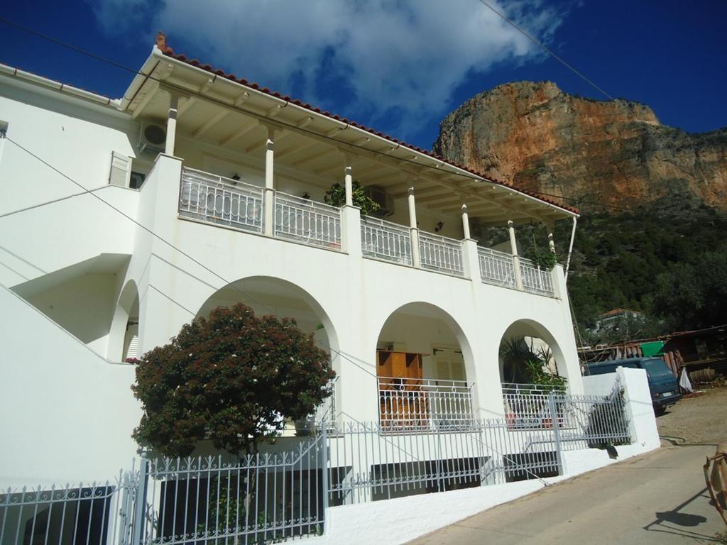 ein weißes Gebäude mit einem Berg im Hintergrund in der Unterkunft Leonidio Climb2red home in Leonidi