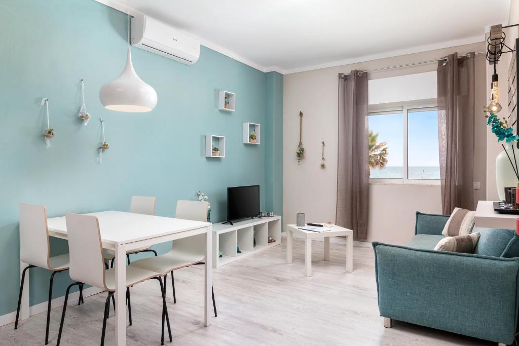 a blue living room with a table and chairs at Apartamento Ocean Dreams in Quarteira