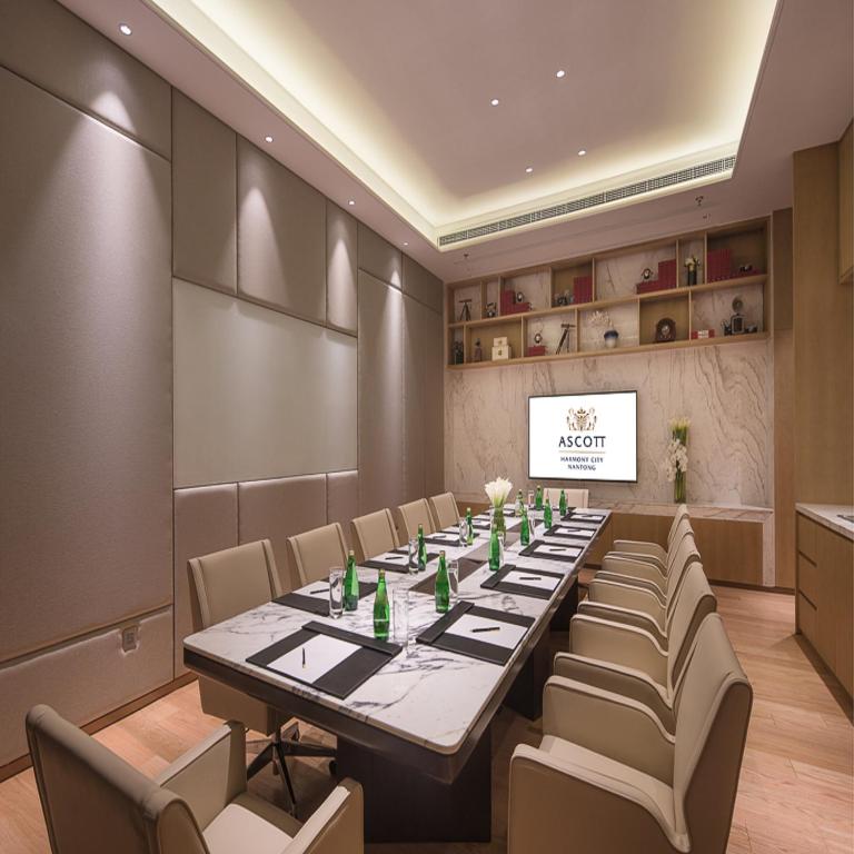 una sala conferenze con un lungo tavolo e sedie di Ascott Harmony City Nantong a Nantong