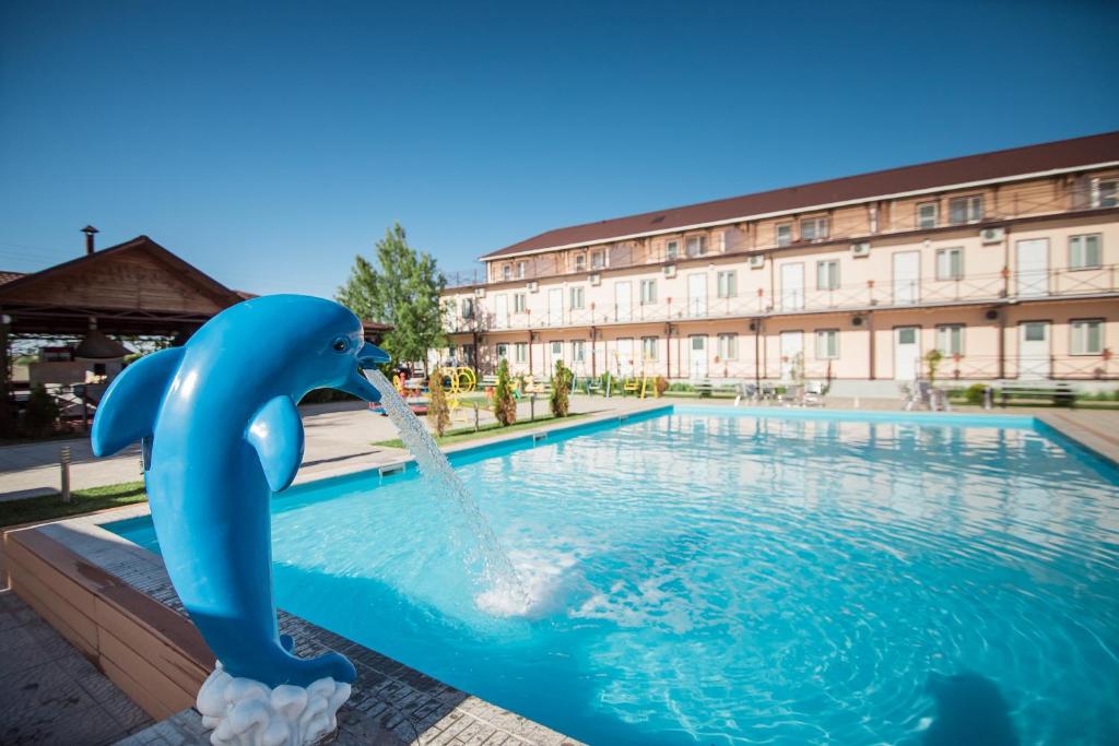 a dolphin water fountain in a swimming pool at Picnic Park in Shenggeldi