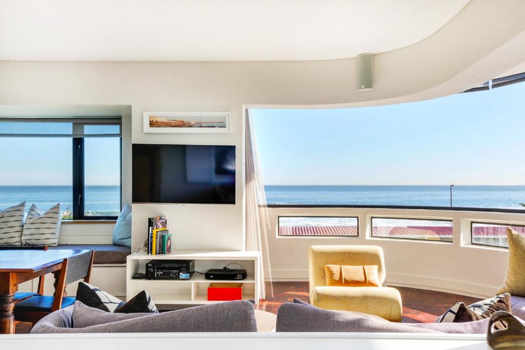 a living room with a view of the ocean at Backup Powered Sea View Apartment on the Promenade in Cape Town