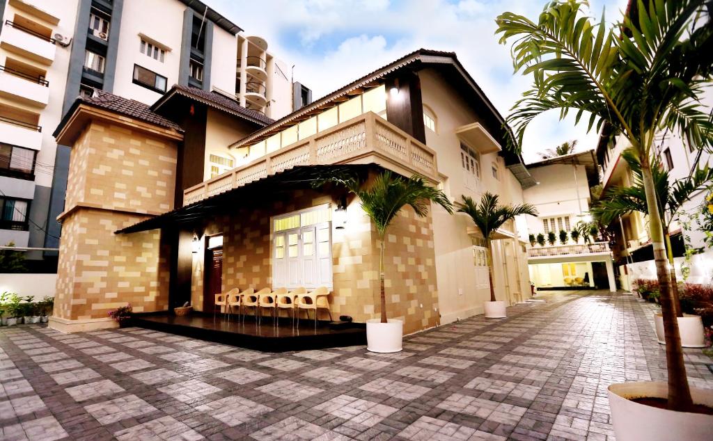 een gebouw met palmbomen ervoor bij Nambiars Premium Heritage Hotel in Cochin